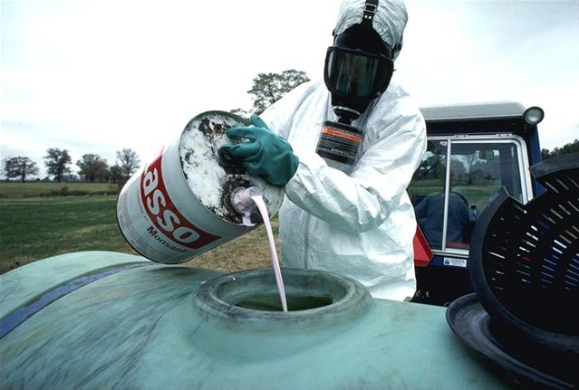 Agricoltore che versa pesticida nel serbatoio dell'irroratrice